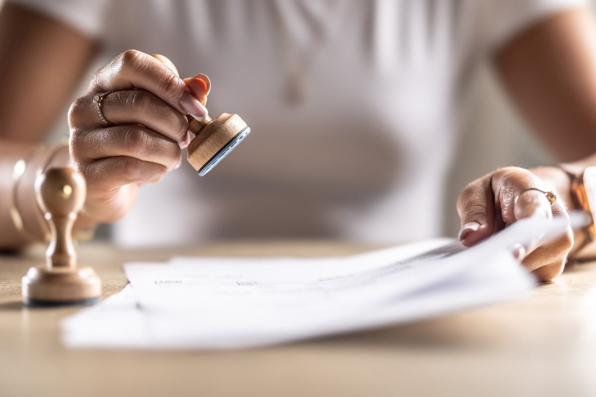 The notary office assistant stamps the archived document.