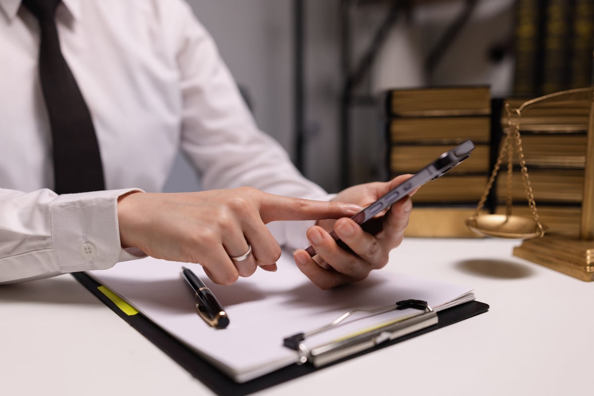 Justice and laws concept. Lawyer businesswoman use mobile phone with law book in a modern office.