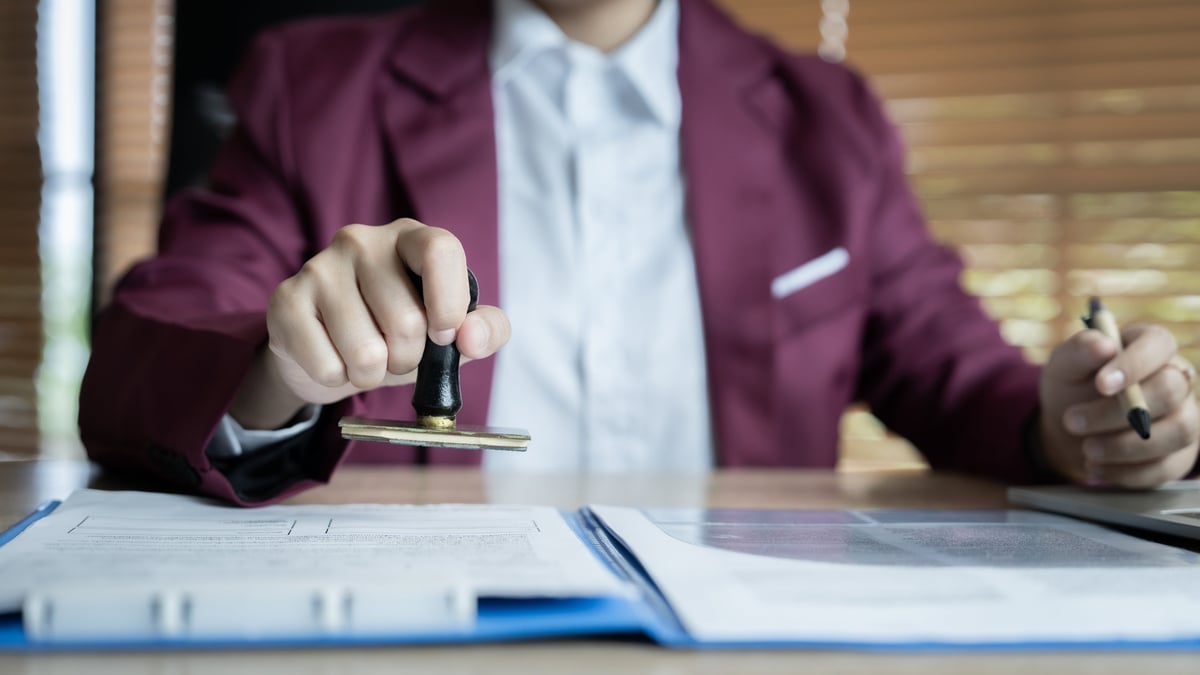 A man in a suit is stamping a document.